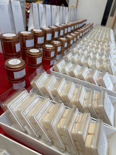 Rows of small containers with labels, arranged neatly on a table.